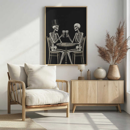 A vintage-style black and white illustration of two skeletons sitting at a round table, toasting each other with wine glasses. One skeleton wears a black top hat, and the background is solid black. Decor