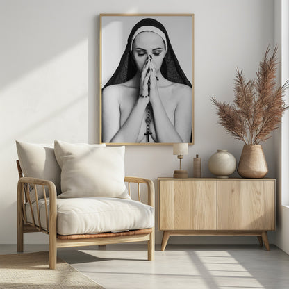 A black and white portrait of a woman with dramatic eye makeup wearing a nun's habit. Her eyes are closed and her hands are clasped in front of her face in prayer, holding a black rosary. Her shoulders are bare, creating a stark contrast. Artwork