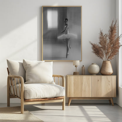 A black and white artistic photograph of a ballerina in a white leotard and tutu, mid-pose on pointe. The image has a motion blur effect, creating a dreamy and ethereal atmosphere as she glances back at the camera. Decor