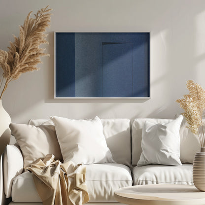 An abstract geometric artwork featuring textured panels in various shades of deep and dusty blue. The composition is divided into vertical sections, with a central rectangular shape that appears slightly recessed, creating a strong shadow line at its top edge. The piece is enclosed in a simple, brushed silver frame. Wall Art