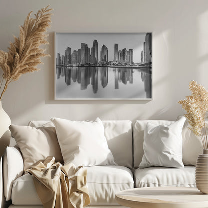 A framed black and white photograph of the Dubai Marina skyline, with its modern skyscrapers perfectly reflected in the calm water of the canal. Decor