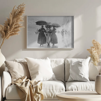 A vintage black and white photograph in a silver frame, depicting three people in long dark coats walking together under umbrellas during a heavy snow or rain storm on a city street. The image has a grainy, textured quality, giving it an old-fashioned, artistic feel. Poster