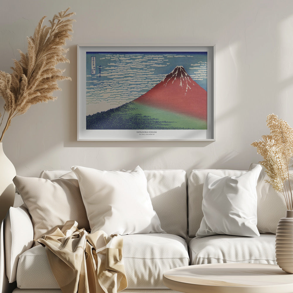 A framed Japanese woodblock print, 'Fine Wind, Clear Morning' by Katsushika Hokusai, also known as 'Red Fuji'. The print depicts a large, reddish-brown Mount Fuji with its peak lightly dusted with snow, set against a vibrant blue sky filled with white, streaky clouds. A dark green forest covers the base of the mountain. Poster