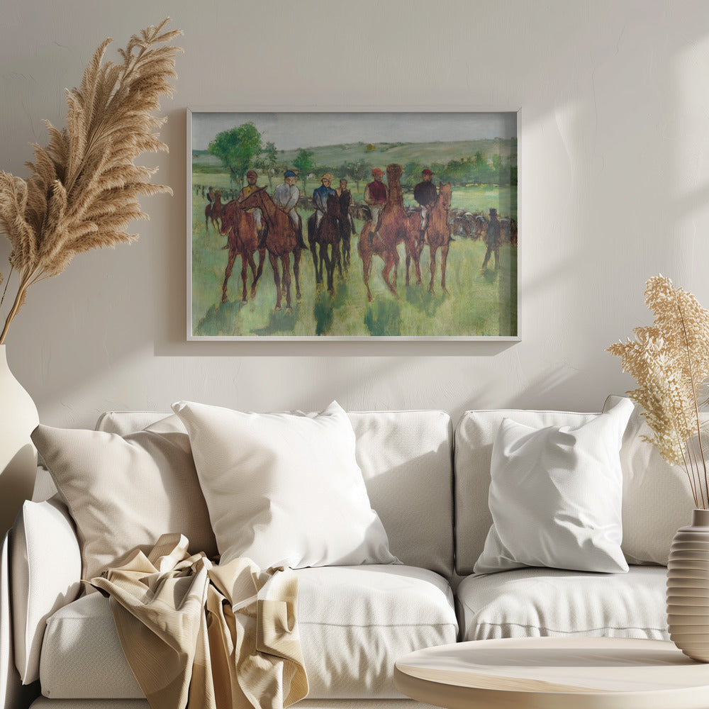 An impressionist painting by Edgar Degas titled 'The False Start', depicting a group of jockeys on their racehorses in a verdant field. The riders are dressed in colorful caps and silks, waiting against a backdrop of rolling green hills and a pale sky. The artwork is displayed in a modern silver frame. Artwork