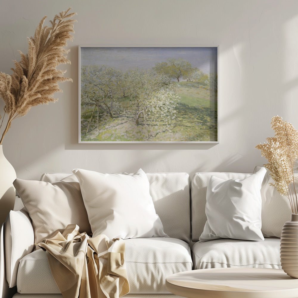 An impressionist painting of an orchard in full bloom, with white and yellow blossoms covering the trees. The orchard is set on a rolling green hillside under a pale, hazy sky, with soft shadows cast on the grass. The artwork is presented in a silver frame. Wall Art