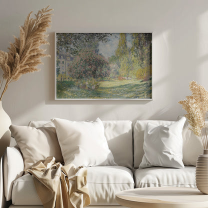 An impressionist painting by Claude Monet titled 'The Parc Monceau' displayed in a silver frame. The scene depicts a sunlit park with lush green grass, a large pink-flowering bush, and tall, leafy trees under a pale blue sky. Decor