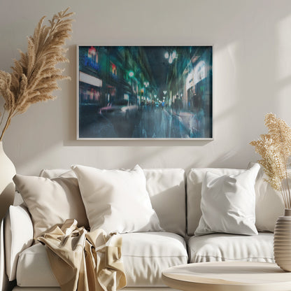 An abstract, moody artwork of a busy city street at night, viewed as if through a rainy window or with motion blur. The scene is dominated by shades of deep blue and vibrant green, with glowing streetlights and neon signs casting reflections on the wet pavement. Silhouettes of people walk down the street, and a car is partially visible on the left. The entire composition has a dynamic, dreamlike quality and is presented in a silver frame. Poster