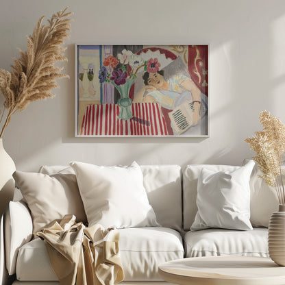 A Fauvist-style painting by Henri Matisse depicting a woman in a colorful blouse reclining with a book. Beside her is a table with a bold red-and-white striped cloth holding a light green vase with red, purple, and white anemone flowers. Print