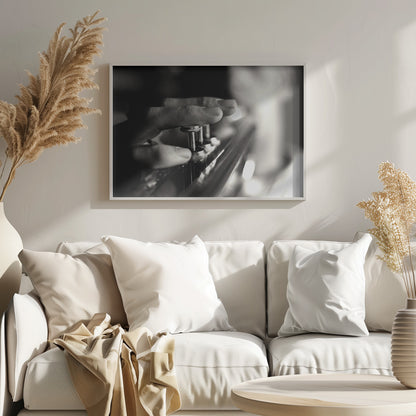 A dramatic, close-up, black and white photograph of a musician's fingers pressing down on the silver valves of a trumpet, with a soft, out-of-focus background. The image is enclosed in a brushed silver frame. Poster