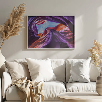 A low-angle photograph looking up from inside a vibrant slot canyon. The smooth, flowing sandstone walls are colored in rich shades of purple, red, and orange, curving around an opening that reveals a bright blue sky with wispy clouds. The image is presented within a silver-colored frame. Wall Art