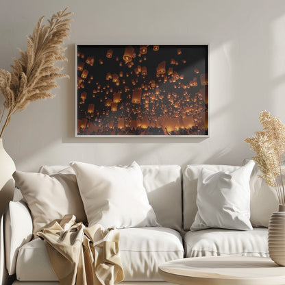 A framed photograph of a sky lantern festival at night, with hundreds of warm, orange-glowing lanterns floating up into the pitch-black sky from a crowd of people below. Artwork