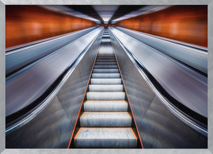 A symmetrical, low-angle photograph looking up a very long escalator, creating a strong sense of perspective towards a vanishing point. The orange walls are motion-blurred, suggesting speed, while the metallic steps in the center remain clear. Decor