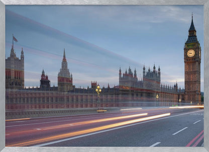 A framed, long-exposure photograph of London's Big Ben and the Houses of Parliament at dusk. In the foreground, streaks of red and yellow light from moving traffic blur across a bridge, creating a dynamic contrast with the historic architecture against a twilight sky. Decor