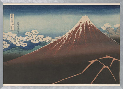 A classic Japanese ukiyo-e woodblock print by Hokusai, 'Thunderstorm Beneath the Summit', depicting a reddish-brown Mount Fuji with its snowy peak against a blue sky. Stylized clouds gather below the summit, and a fork of lightning illuminates the dark landscape at the mountain's base. Print