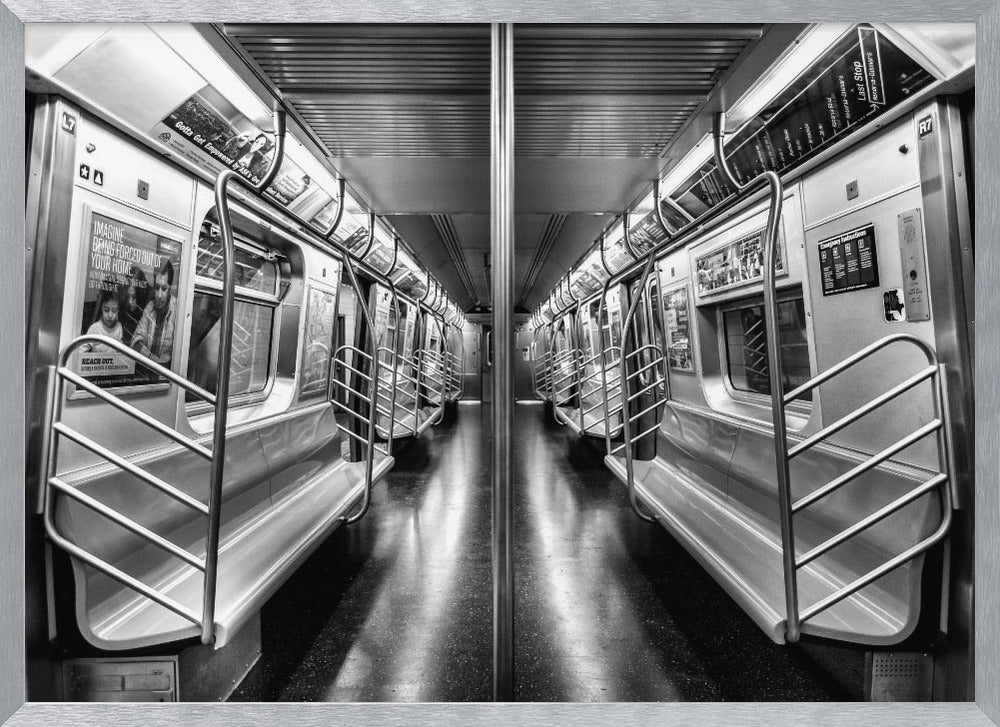A framed, black and white photograph capturing a perfectly symmetrical view down the aisle of an empty subway car. The reflective, dark floor and the metallic seats and handrails create strong leading lines, giving the image a sense of depth and urban solitude. Wall Art