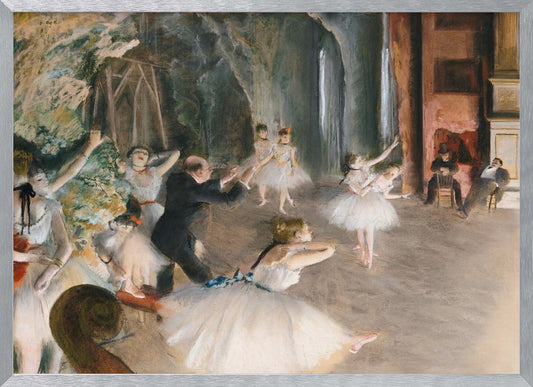 An impressionist painting depicting a ballet rehearsal on a stage. Ballerinas in white tutus practice and stretch while a male instructor in a dark suit directs them. The scene is viewed from the wings, with theatrical scenery in the background and onlookers seated to the right. Wall Art