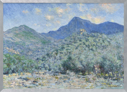 An Impressionist painting by Claude Monet, 'Valle Buona, near Bordighera', showcasing a vast landscape of rolling green hills and deep blue mountains under a light blue sky with wispy clouds. The painting, rendered in soft, textured brushstrokes, is presented in a simple silver frame. Print