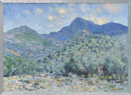An Impressionist painting by Claude Monet, 'Valle Buona, near Bordighera', showcasing a vast landscape of rolling green hills and deep blue mountains under a light blue sky with wispy clouds. The painting, rendered in soft, textured brushstrokes, is presented in a simple silver frame. Print