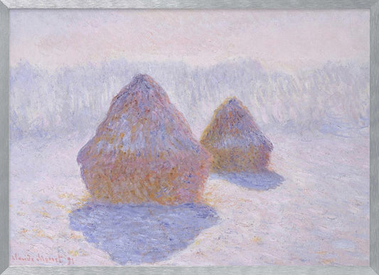 An impressionist painting by Claude Monet titled 'Haystacks,' showing two large, conical haystacks in a snowy field. The scene is bathed in a soft, hazy light, with pinks and oranges on the sunlit side of the haystacks and long, purple shadows cast across the lavender and white snow. The artwork is presented in a simple silver frame. Wall Art