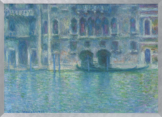 An Impressionist painting by Claude Monet titled 'The Palazzo Contarini,' depicting a grand Venetian building from across a canal. The artwork is characterized by hazy, blended brushstrokes in a cool palette of blues, greens, and purples, creating a misty and atmospheric effect on the water and architecture. A single gondola is moored near the building's entrance. The painting is displayed within a silver frame. Decor