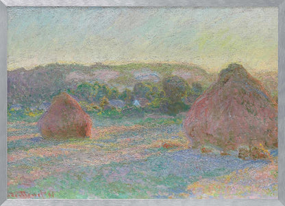 An Impressionist painting by Claude Monet depicting two large, reddish haystacks in a field of green and purple hues during sunrise, with a line of distant trees under a pale yellow sky, all within a silver frame. Poster