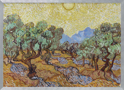 A framed Post-Impressionist painting by Vincent van Gogh depicting an olive grove under a bright yellow sun and sky. The olive trees have gnarled brown trunks and green leaves, set against a rolling landscape of ochre and lavender shadows. In the distance, blue mountains rise against the vibrant sky. The entire scene is painted with thick, energetic brushstrokes. Decor