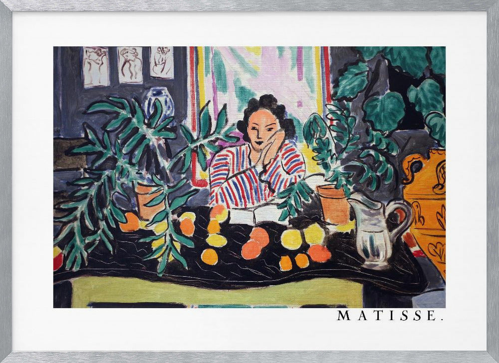 A framed print of the painting 'Woman with a Book' by Henri Matisse. The artwork features a woman in a red, white, and blue striped shirt sitting at a dark table filled with potted green plants and colorful fruit. She rests her head on her hand, looking out from the painting in a Fauvist style with bold colors and expressive brushwork. Poster