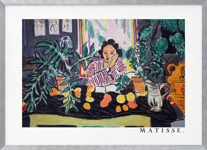 A framed print of the painting 'Woman with a Book' by Henri Matisse. The artwork features a woman in a red, white, and blue striped shirt sitting at a dark table filled with potted green plants and colorful fruit. She rests her head on her hand, looking out from the painting in a Fauvist style with bold colors and expressive brushwork. Poster