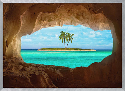 A framed artwork depicting a view from inside a rocky cave looking out at a small tropical island with two palm trees. The cave's natural arch frames the vibrant turquoise ocean and the bright blue sky, creating a sense of a hidden paradise. Artwork