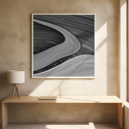A framed black and white abstract artwork featuring a dynamic composition of flowing, wave-like forms created from dense, parallel lines. Lighter-toned curves sweep across the canvas, overlapping darker areas and creating a sense of depth, texture, and movement. Decor