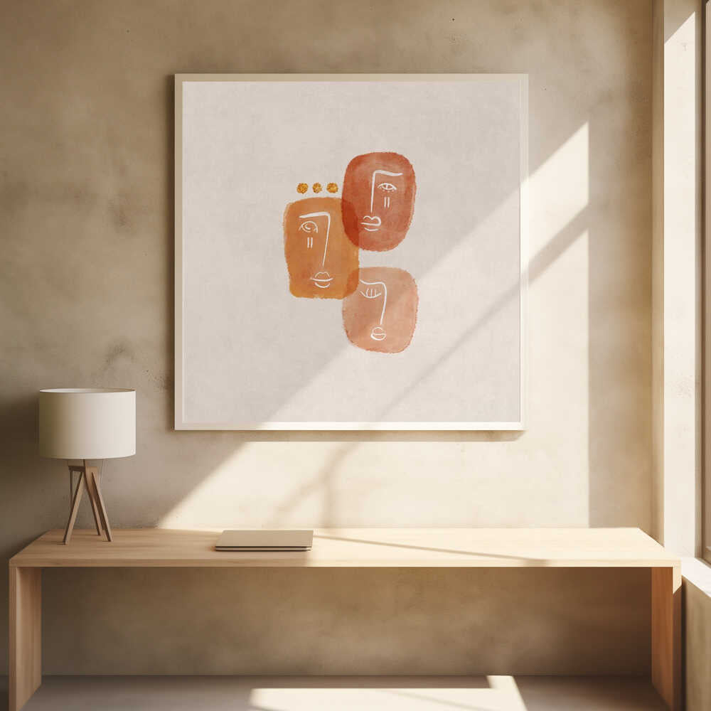 A minimalist abstract painting in a light wood frame, featuring three stylized faces rendered in orange and terracotta watercolor shapes with simple white line art on a textured beige background. One face is adorned with three small gold dots above it. Artwork