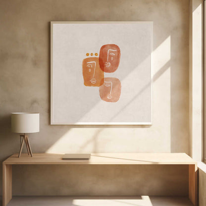 A minimalist abstract painting in a light wood frame, featuring three stylized faces rendered in orange and terracotta watercolor shapes with simple white line art on a textured beige background. One face is adorned with three small gold dots above it. Artwork