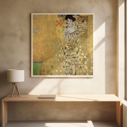 A framed print of Gustav Klimt's 'Portrait of Adele Bloch-Bauer I,' also known as 'The Woman in Gold.' The painting depicts a woman in an ornate, gilded gown covered in intricate patterns, blending into a shimmering gold background characteristic of the Art Nouveau style. Poster