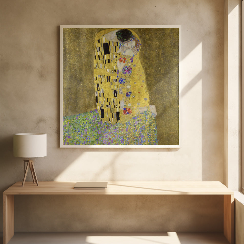 A framed print of Gustav Klimt's famous painting, 'The Kiss'. It features a couple in a passionate embrace, adorned in ornate, patterned golden robes. They are kneeling on a vibrant bed of flowers against a shimmering, textured gold background. Print