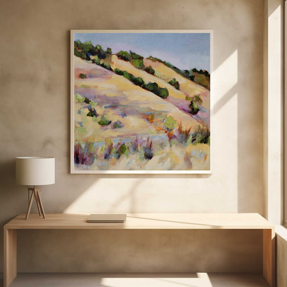 An impressionist oil painting of golden, rolling hills dotted with green shrubs under a pale blue sky, framed in light wood.