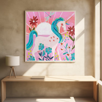 A whimsical painting of a serene white unicorn with a vibrant blue mane and tail, standing in a field of colorful flowers. The background features a large white sun against a pink sky with a dragonfly flying overhead. The artwork is presented in a light wood frame. Print
