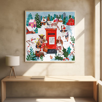 A whimsical Christmas illustration of several dogs in festive hats and scarves mailing letters at a bright red postbox labeled 'Letters to the North Pole' in a snowy village scene with colorful houses and pine trees. Decor