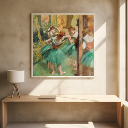 An impressionist painting of four ballet dancers in green tutus backstage. The dancers are adjusting their costumes and hair against a warm, painterly background of yellow, orange, and brown tones. The artwork is displayed in a light wood frame. Wall Art