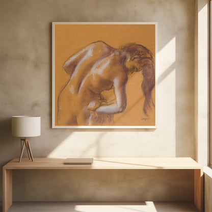 A framed pastel sketch by Edgar Degas titled 'After the Bath, Woman Drying Herself'. The artwork depicts a nude woman from the back, bending forward as if drying herself. The drawing is on a warm ochre-colored paper, with her form defined by brown lines and white highlights, especially along her spine and shoulders. Her long brown hair cascades down on the right side. Wall Art