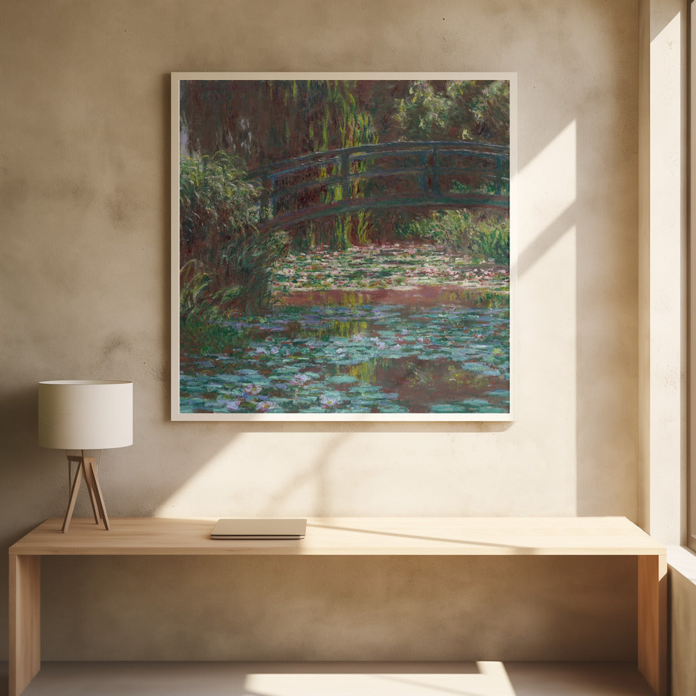 An impressionist painting by Claude Monet of the Japanese bridge over his water lily pond. The artwork, framed in light wood, is rich with shades of green from the foliage and lily pads, and deep brown and blue tones in the water and the bridge itself. Wall Art