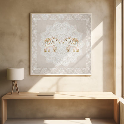 A framed artwork depicting two small, ornate elephants facing each other in the center, their trunks touching. They are decorated with colorful floral patterns and stand against a large, intricate white mandala on a light beige background. The piece is bordered with a white pattern and set in a light wood frame. Wall Art