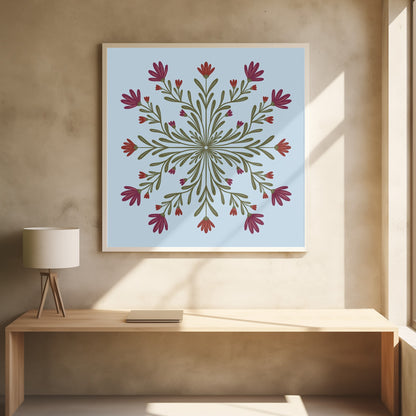 A framed art print with a symmetrical floral mandala on a light blue background. Olive green stems and leaves radiate from the center, blooming with magenta and red flowers. The artwork is enclosed in a light wood frame. Wall Art