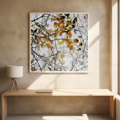An abstract artwork in a light wood frame featuring a dense tangle of black and grey branches interwoven with soft, glowing autumn leaves in shades of orange and yellow against a white background. Poster